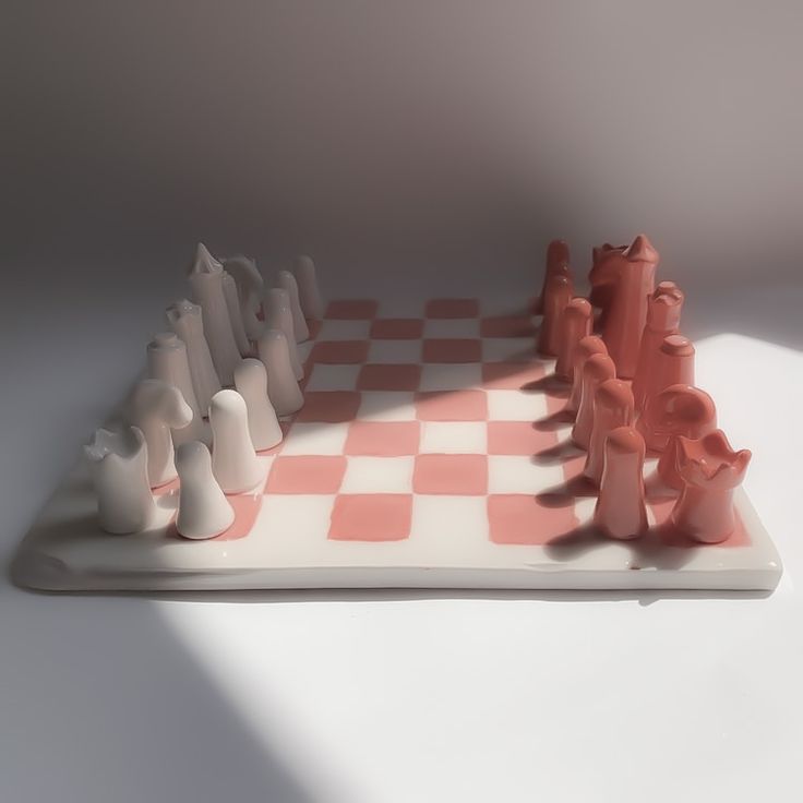 a chess board with several pieces in the shape of animals on it and one is white and pink