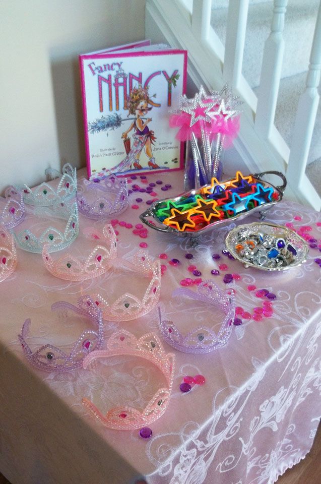 a table topped with lots of tiaras next to a greeting card and other items