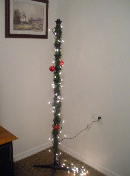 a christmas tree with lights and ornaments on it in the corner of a living room