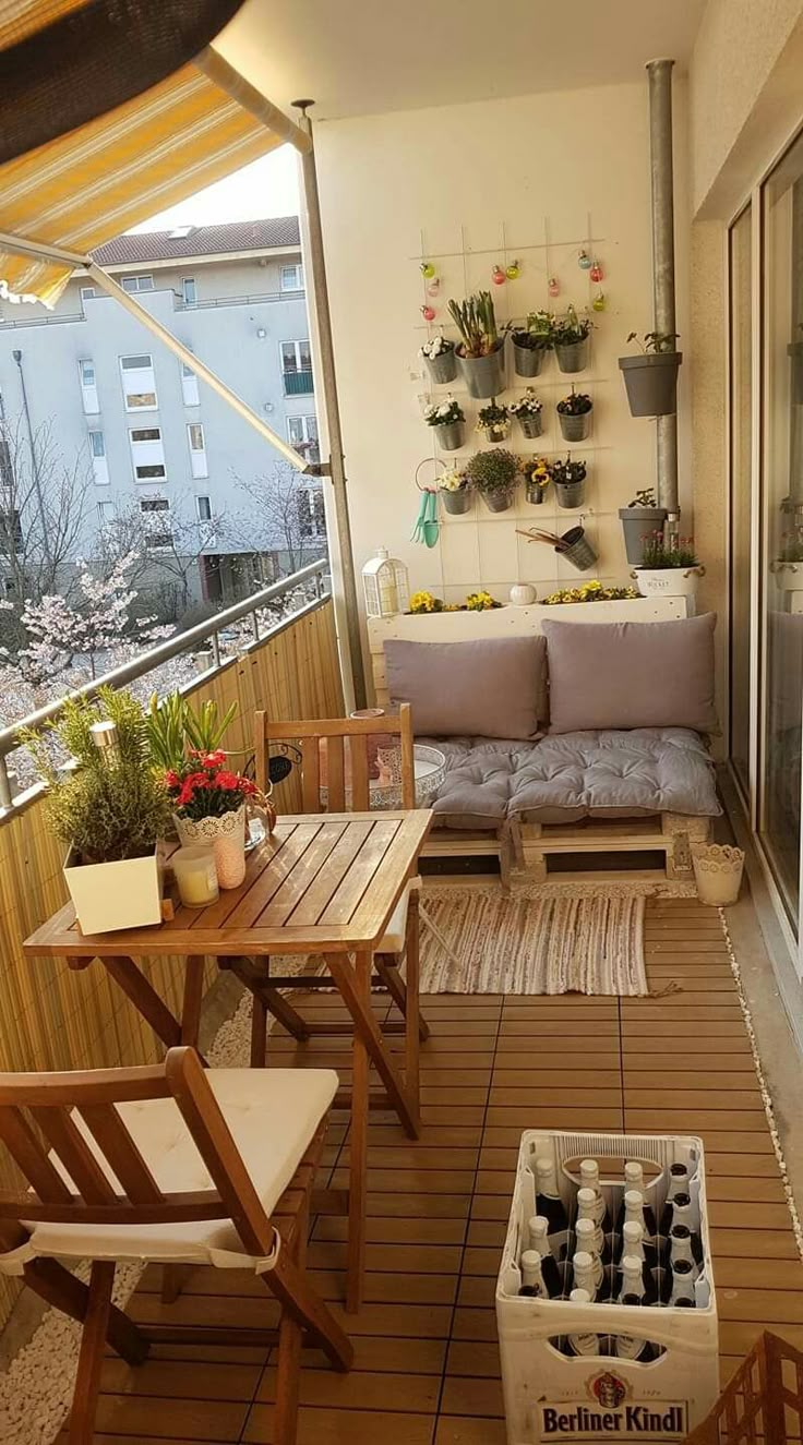 an outdoor patio with wooden furniture and potted plants