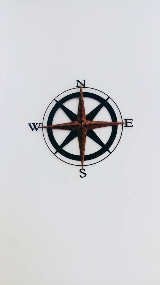 a compass on the side of a white wall