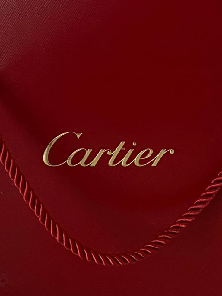 the cartier logo is engraved on the side of a red leather bag with gold lettering