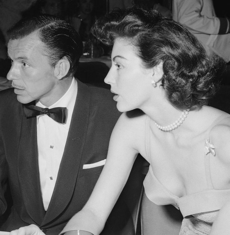 a man in a tuxedo sitting next to a woman