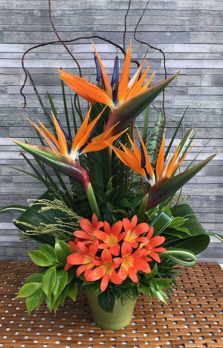 an arrangement of tropical flowers on a table