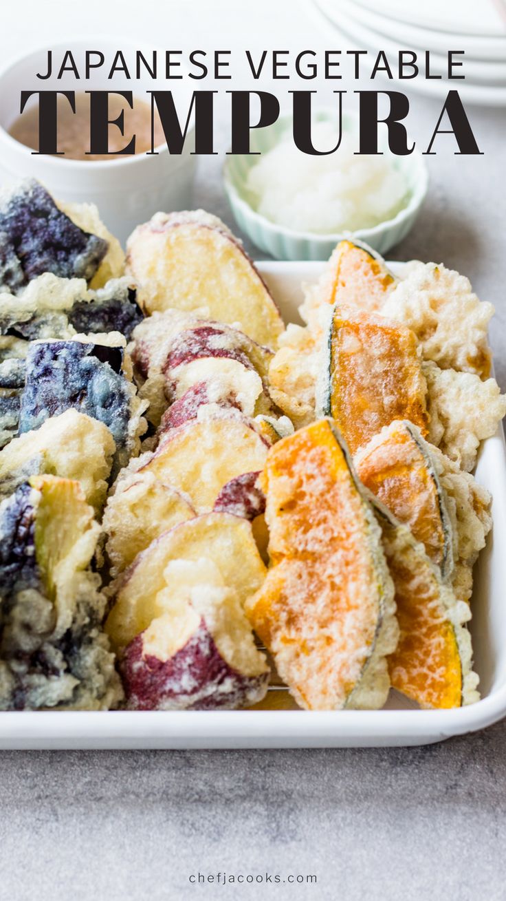 japanese vegetable tempura is served in a white dish with blueberries and oranges