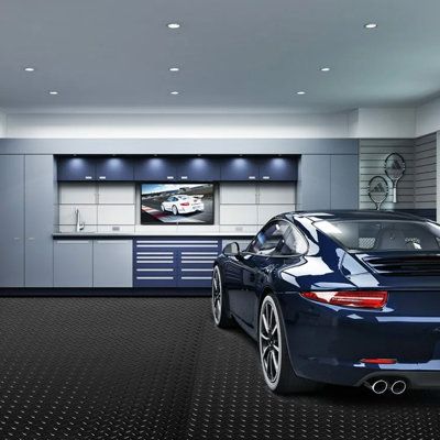 a blue sports car is parked in a garage with an entertainment center on the wall