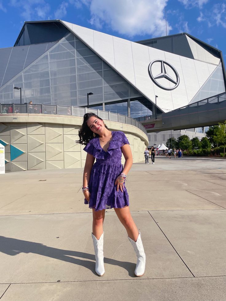 a woman standing in front of a mercedes building