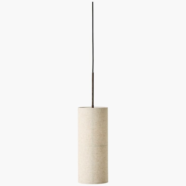 a lamp that is hanging from the ceiling in front of a white wall with a black stick sticking out of it