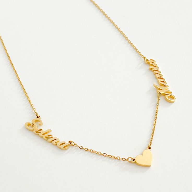 Double the name, double the love. Our two name necklace featuring a heart pendant is a beautifully unique custom piece for your jewellery collection or a special gift for someone special. Our two name heart necklace is crafted from high quality, water and tarnish resistant stainless steel for a long lasting finish so you can wear this necklace every day. Choose from 18k gold coating, rose gold or stainless steel. Yellow Gold Necklaces With Names For Anniversary, Gold Name Necklaces For Anniversary, Gold Necklaces With Names For Anniversary, Gold Charm Necklace With Names For Anniversary, Gold Heart-shaped Name Jewelry, Customized Heart Pendant Charm Necklaces For Anniversary, Gold Charm Necklaces With Names For Anniversary, Gold Charm Necklace For Anniversary With Names, Heart-shaped Gold Jewelry With Names