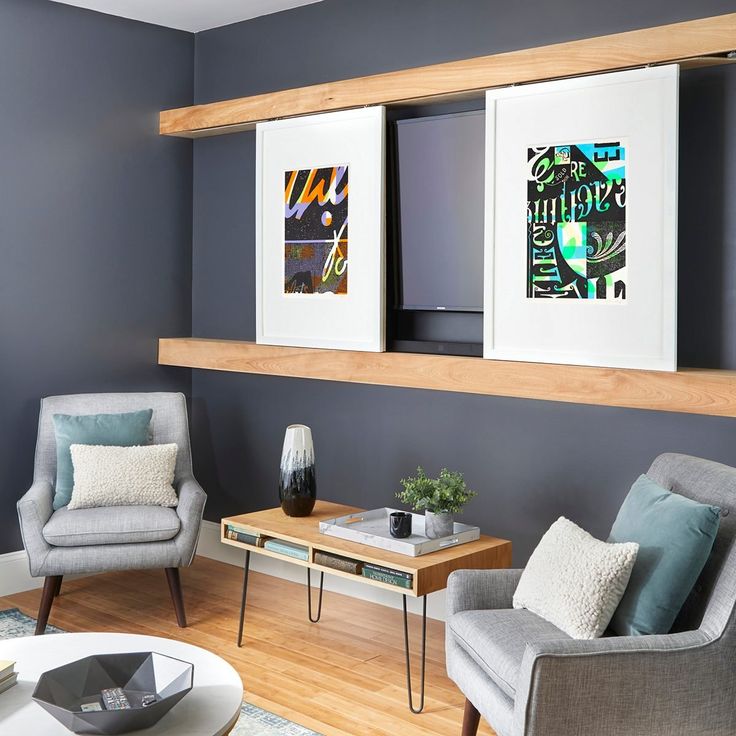 a living room with two chairs and a coffee table in front of the tv on the wall