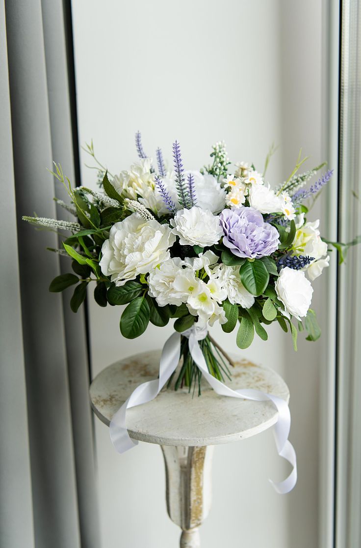 a vase filled with white and purple flowers