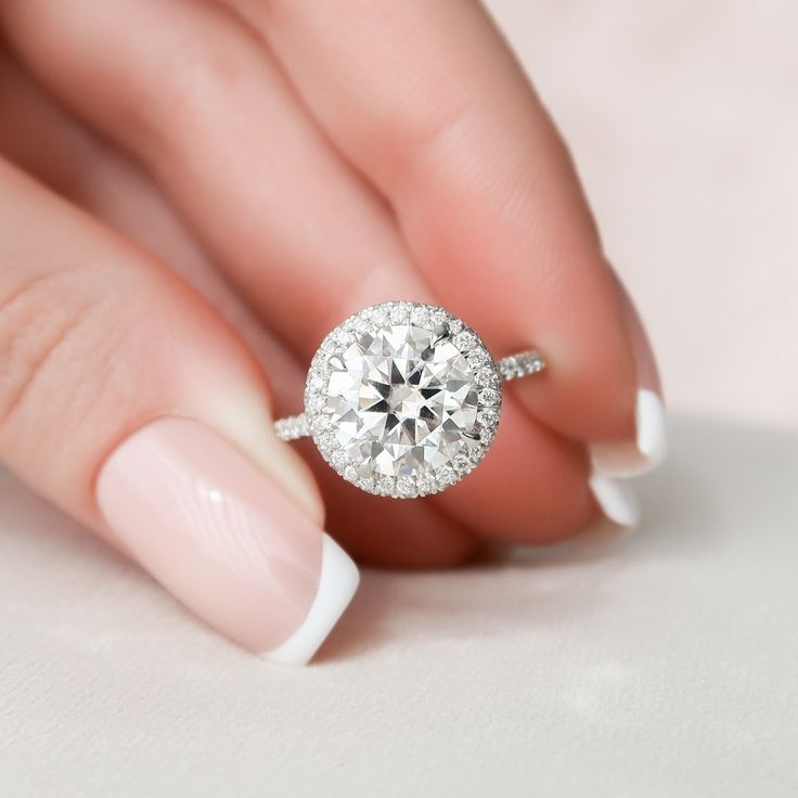 a woman's hand with a ring on her finger and a diamond in the middle