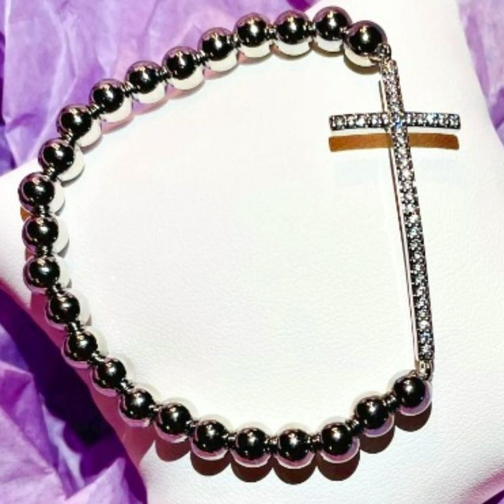 Favorite Diamond Cross Bracelet Our Favorite Diamond Cross Bracelet Is A Fashionable Way To Show Your Faith! The Side Way Cross Is Lined With Cubic Zirconia, Resembling The Luster Of Real Diamonds And Metallic Beads For Everyday Wear. Add Some Spirituality To Your Stack With Lisa's Favorite Diamond Cross Bracelet. Measures 6.85" And It Is Made With Elastic. Stunning!!! Elegant Silver Cross Beaded Bracelets, Elegant Silver Beaded Cross Bracelets, Adjustable Silver Beaded Bracelets With Cross Shape, Adjustable Silver Cross Beaded Bracelets, Adjustable Silver Beaded Cross Bracelets, Silver Jubilee Stretch Bracelet As Gift, Metal Cross Bracelets, Spiritual Silver Charm Bracelet With Cross, Spiritual Silver Cross Charm Bracelet