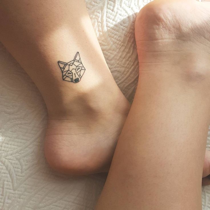 two people with tattoos on their feet laying next to each other, one has a small fox tattoo on it's left ankle