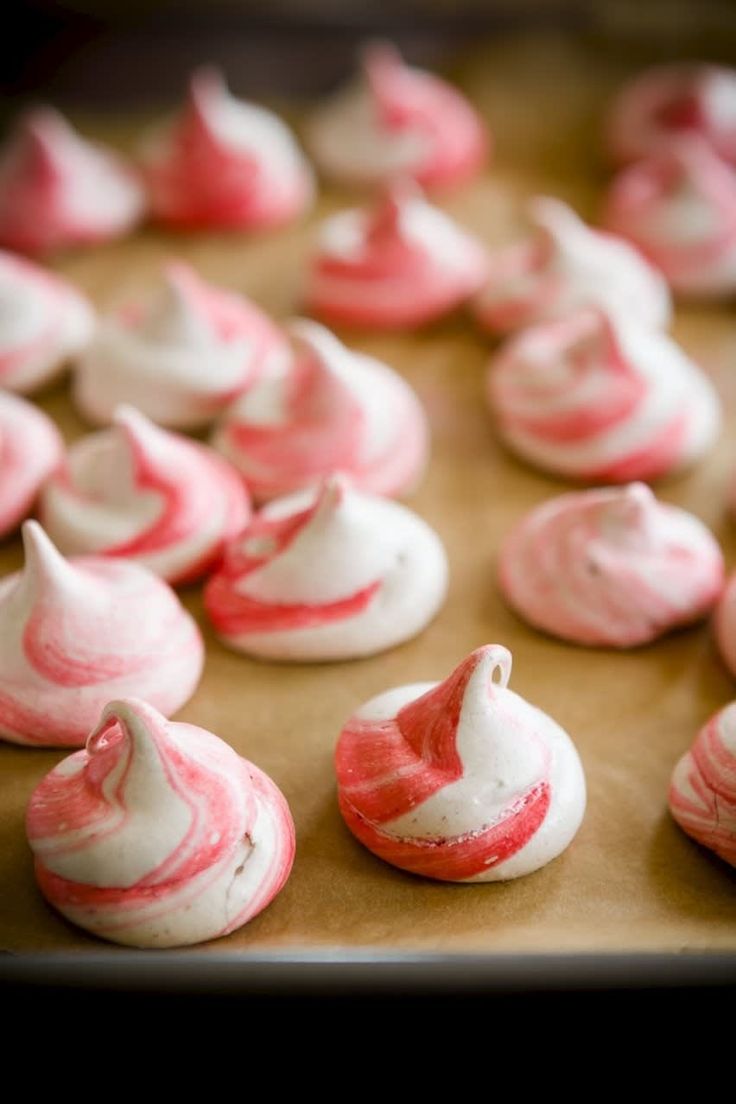 some pink and white icing sitting on top of a cookie sheet covered in frosting