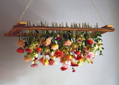 flowers are hanging from a long wooden shelf