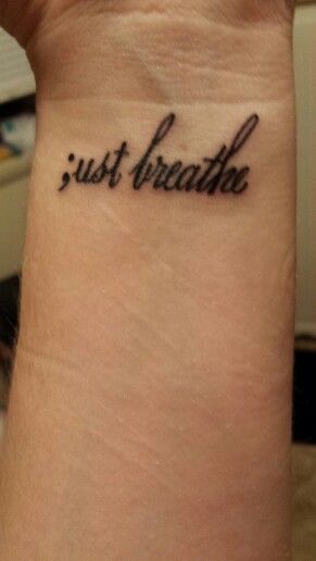 a wrist tattoo with the words just breathe on it