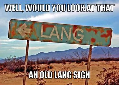 an old rusted road sign in the desert with mountains in the backgroud