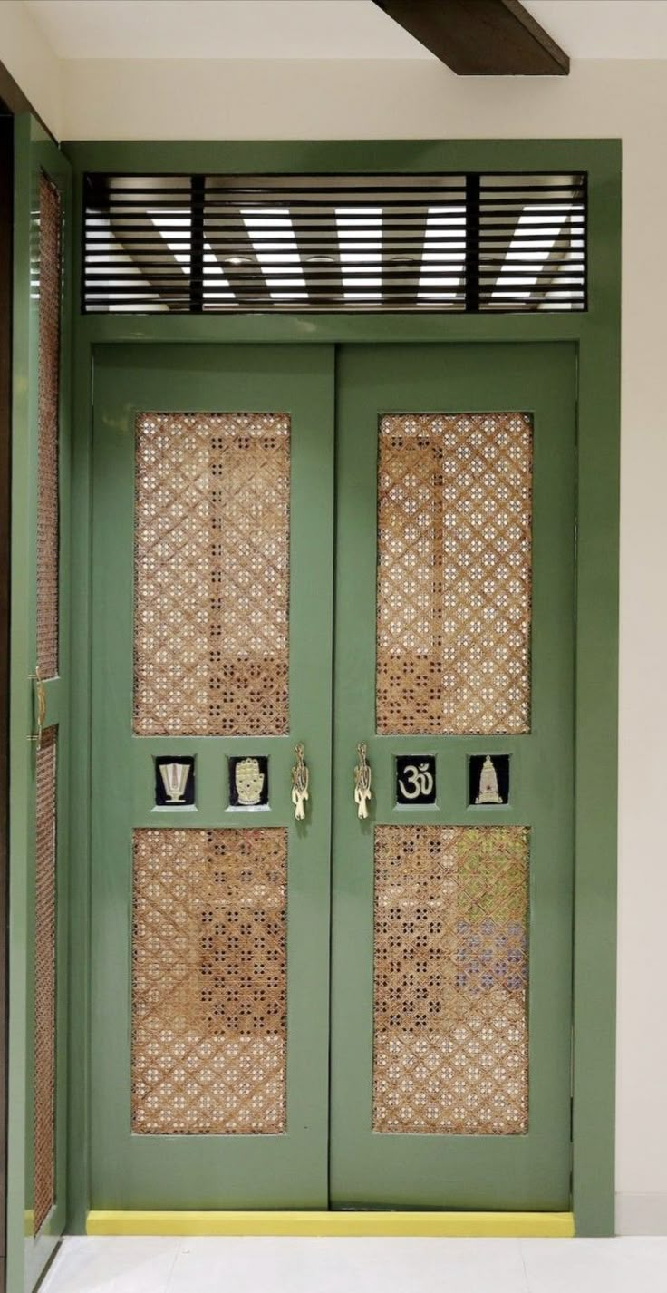 a green door with wicker panels and numbers on the front panel is flanked by a white tile floor