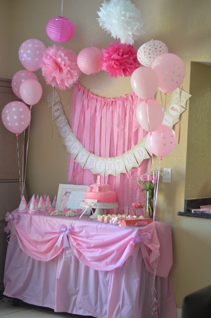 a pink and white dessert table with balloons