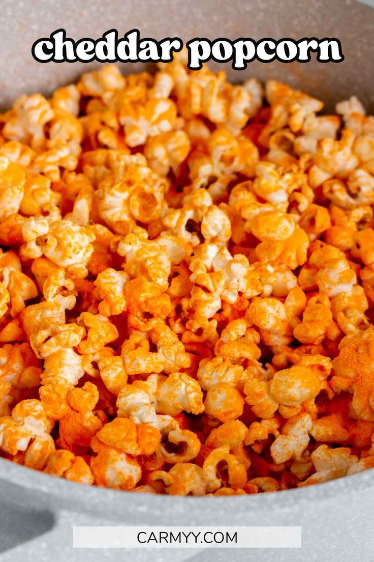 a bowl filled with cheddar popcorn on top of a table