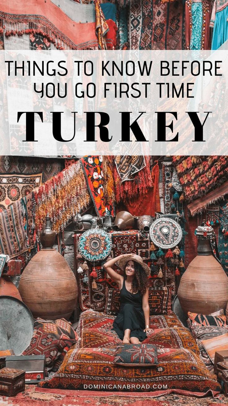 a woman sitting on top of a bed surrounded by rugs and vases with the words, things to know before you go first time turkey