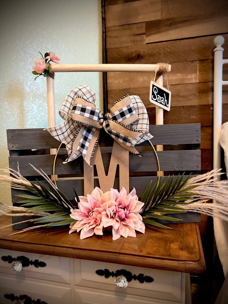 a wooden sign with flowers on top of it