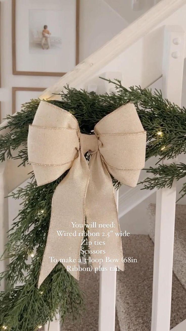 a christmas wreath on the banisters of a staircase with lights and ribbon tied around it