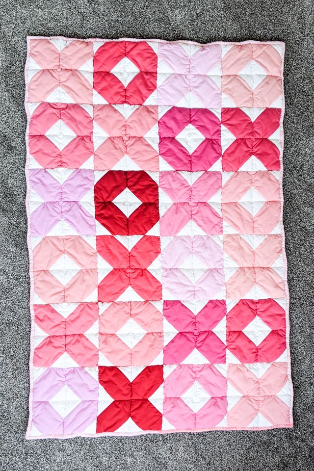 a pink and red quilt with hearts on it