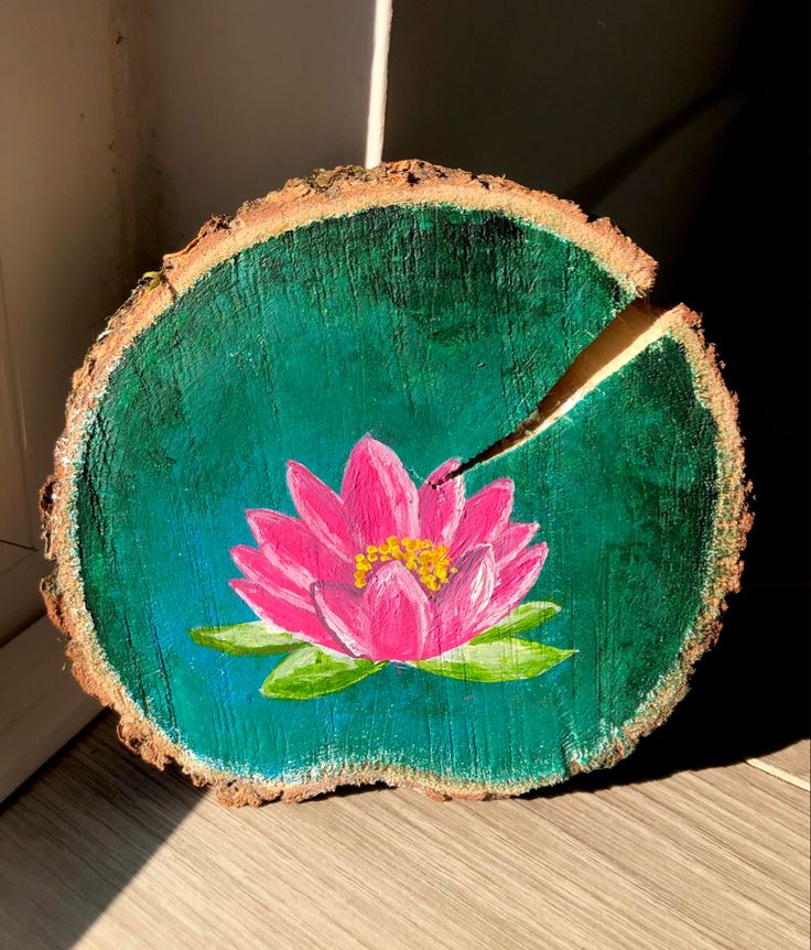 a pink flower painted on a piece of wood