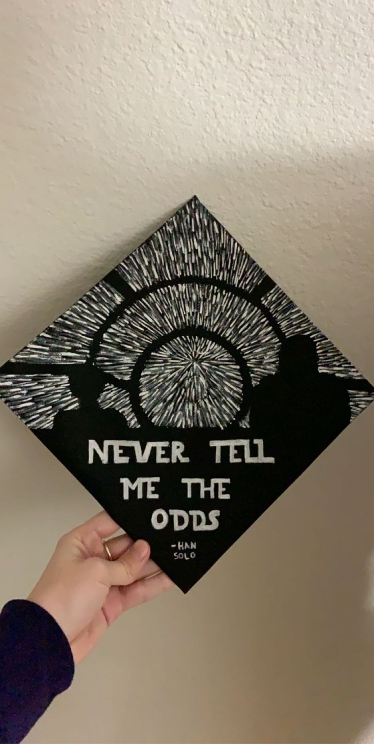 someone holding up a graduation cap that says never tell me the odds