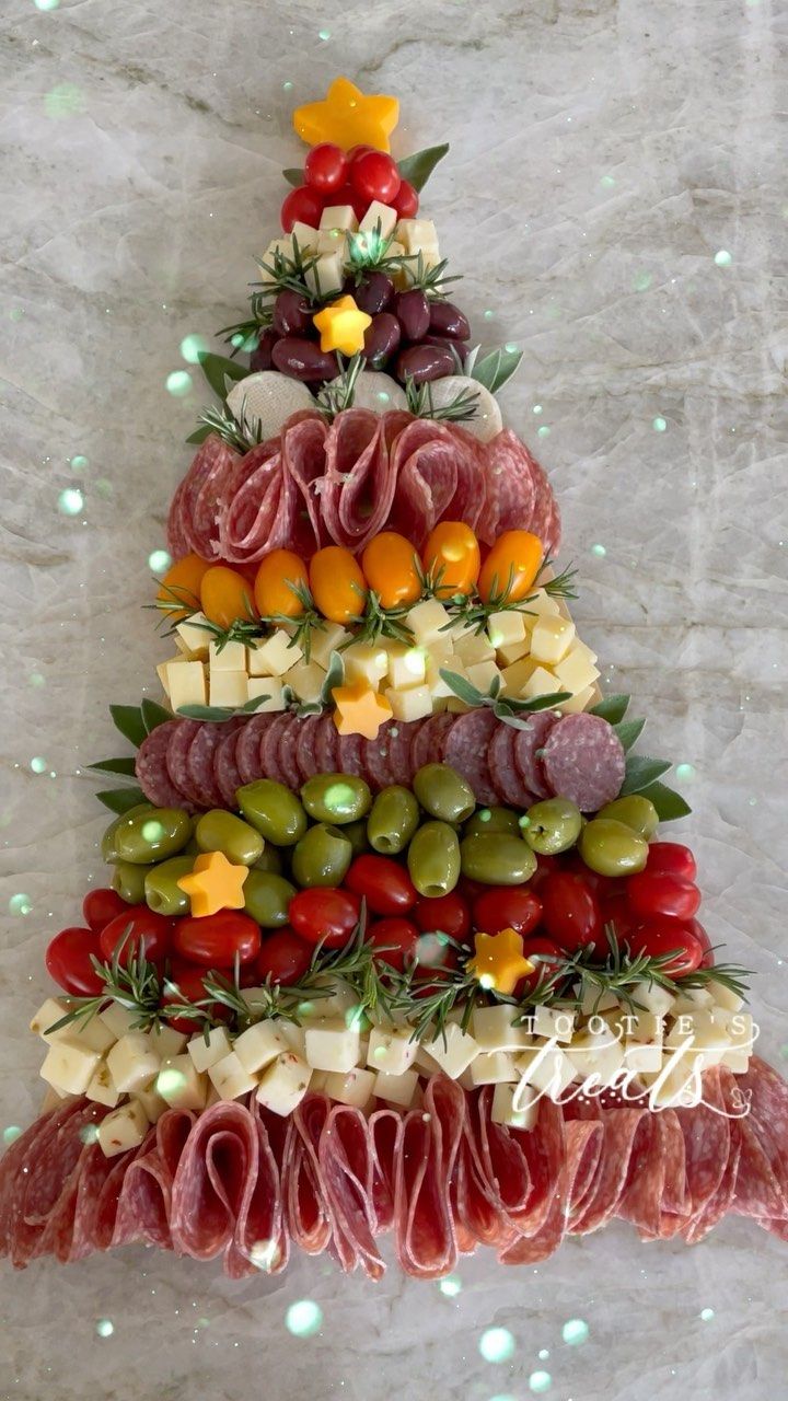 a christmas tree made out of meats, cheeses and vegetables on a marble surface