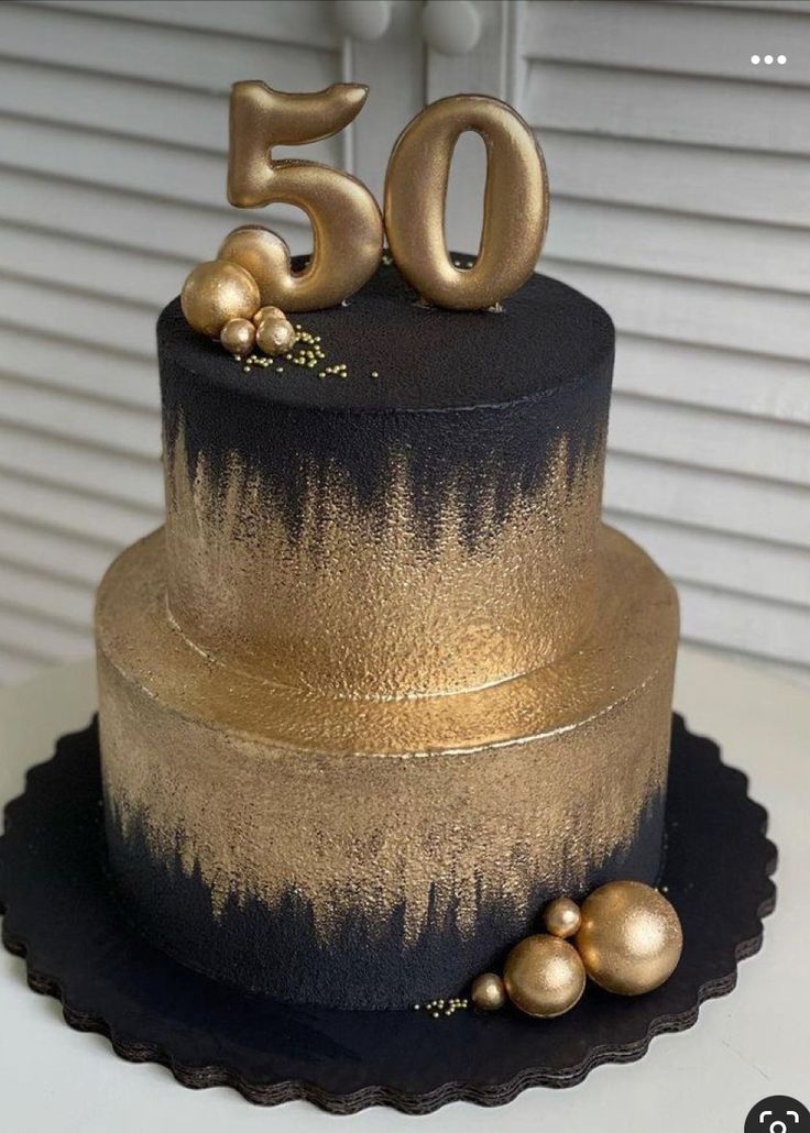 a black and gold cake with the number 50 on top