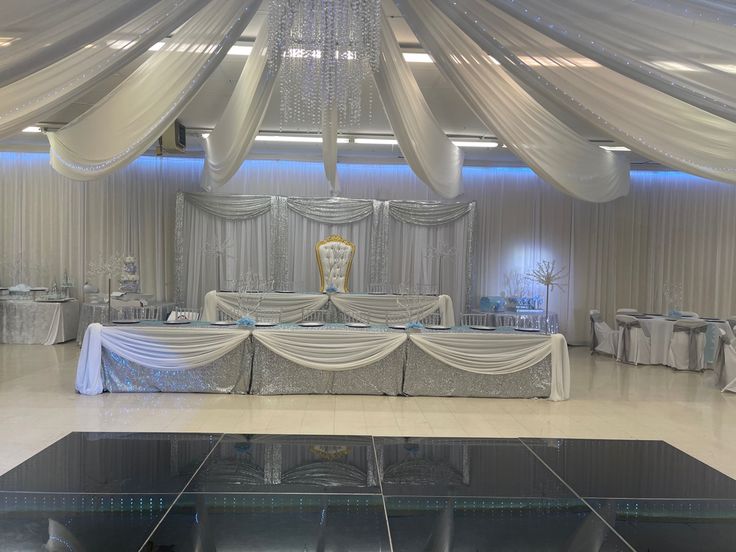 a banquet hall decorated with white linens and draped draping, silver tablecloths and chairs