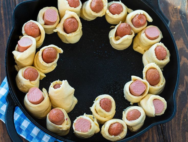 a pan filled with pigs in a blanket on top of a wooden table