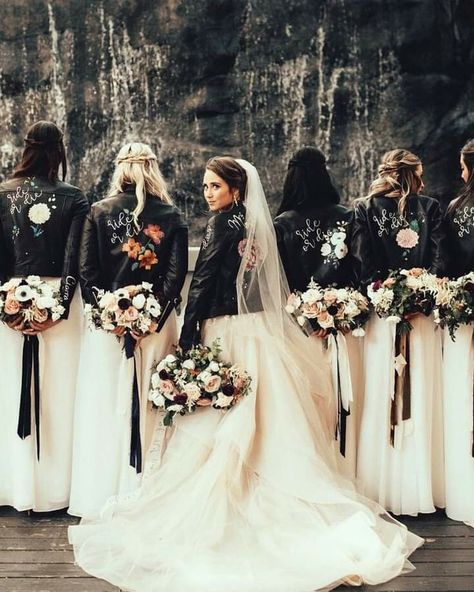 a group of women standing next to each other in front of a waterfall with flowers