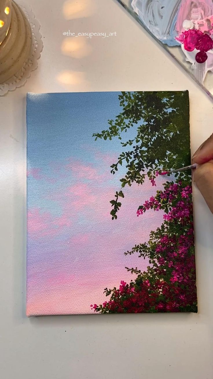 someone is painting the sky and trees with acrylic paint