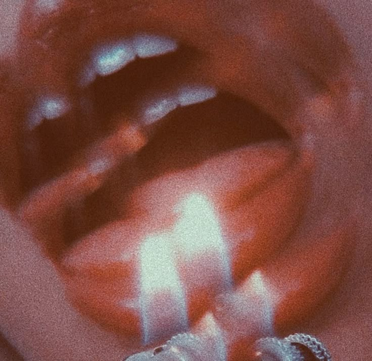 a close up of a person's mouth with candles in it