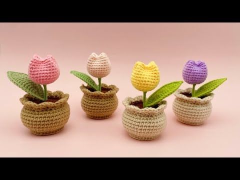 four crocheted pots with flowers in them