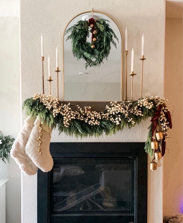 a fireplace with stockings and candles hanging from it's mantle, decorated for christmas