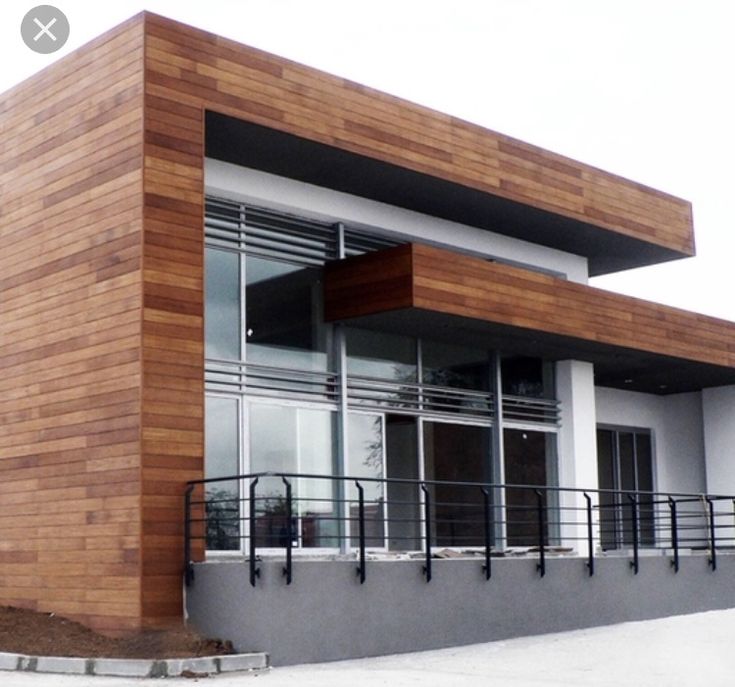 a building that has some windows on the outside and wooden panels on the inside, along with metal railings