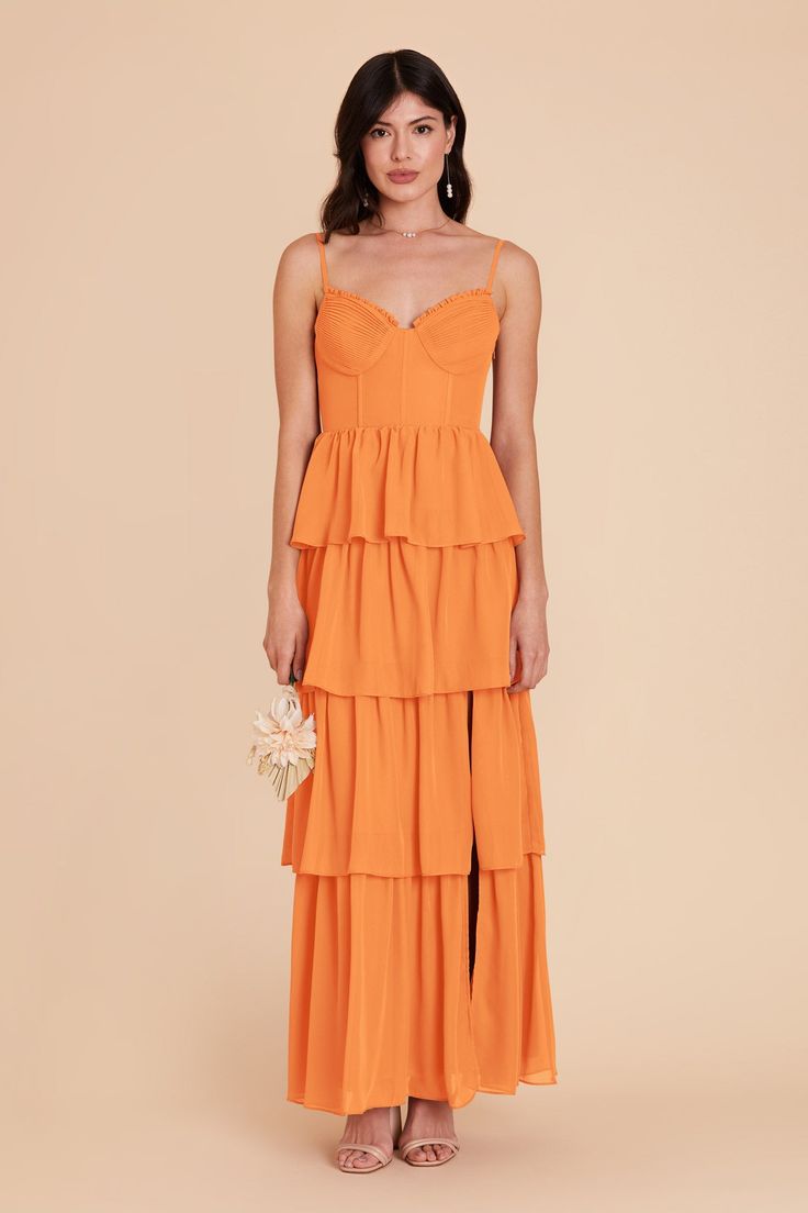 a woman wearing an orange tiered dress