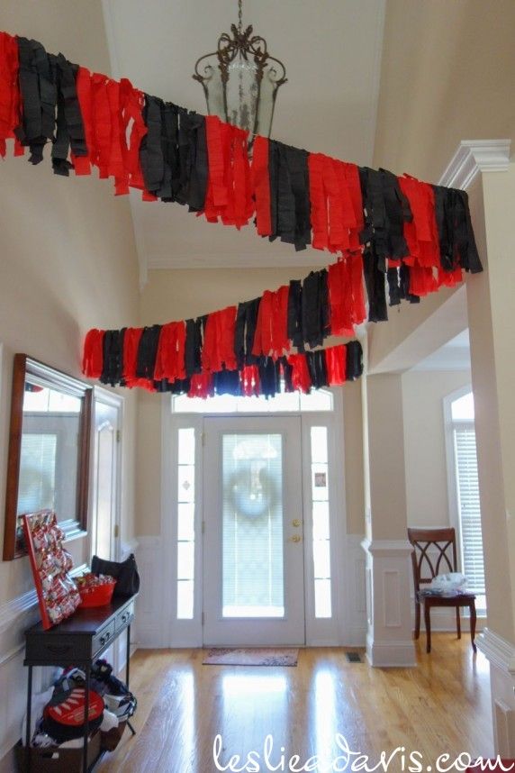 red, black and white streamers hanging from the ceiling in front of a door