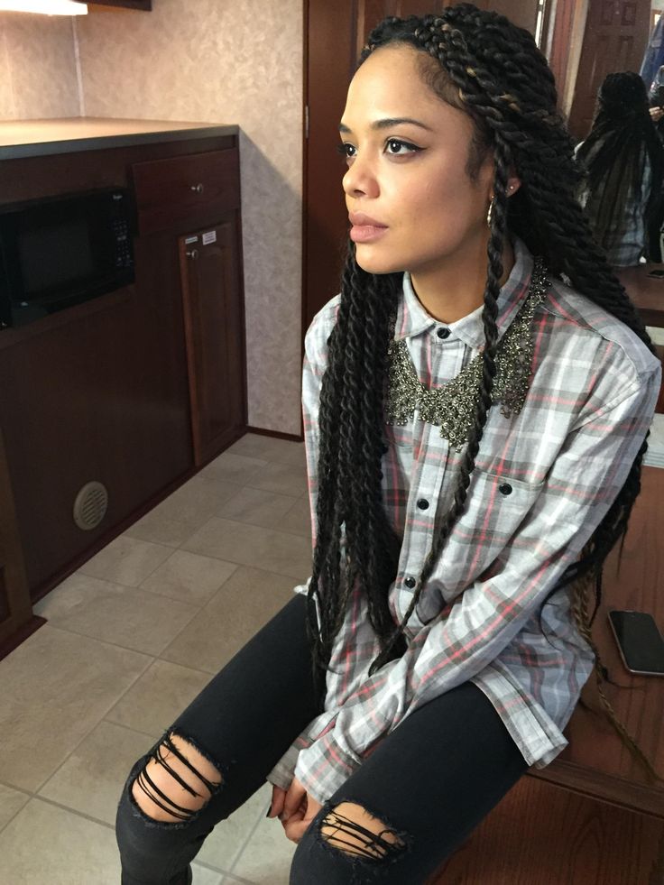 a woman with long braids sitting on the floor