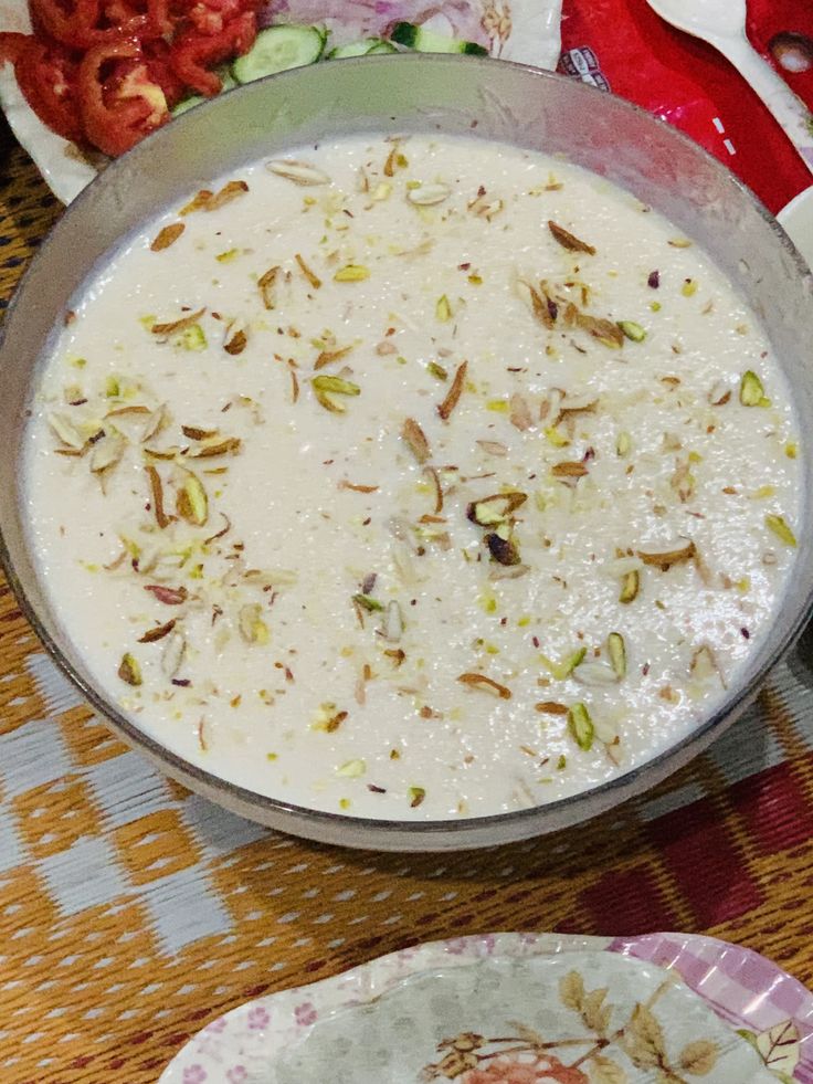 there is a bowl of food on the table with other plates and utensils