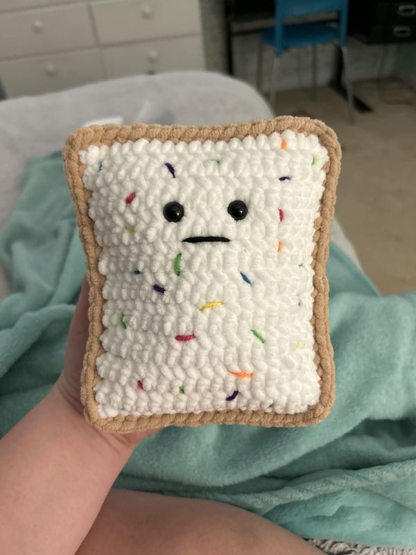 a piece of bread with sprinkles on it in someone's hand