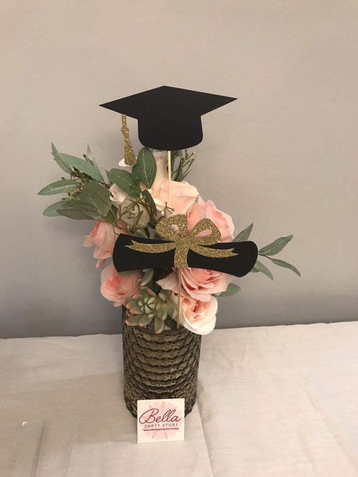 a graduation cap on top of a vase filled with flowers