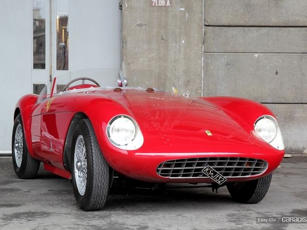 a red sports car parked in front of a building