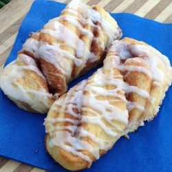 three glazed donuts sitting on top of a blue napkin