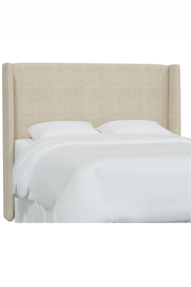 an upholstered headboard on a bed with white sheets and linens,